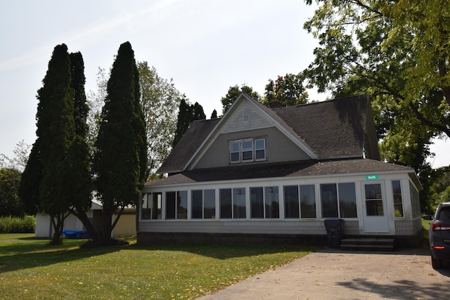 view of front of home featuring a front yard and a sunroom