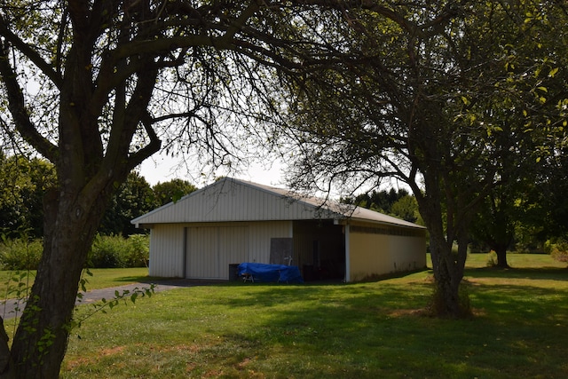 view of side of home with an outbuilding, a lawn, and a garage