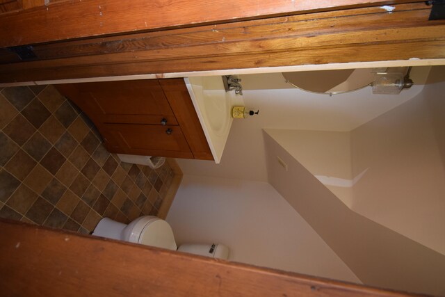 bathroom with tasteful backsplash, tile walls, and toilet