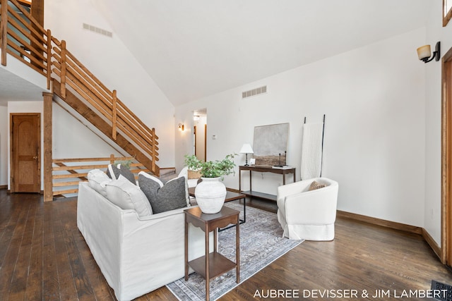 living room featuring dark wood-type flooring and vaulted ceiling