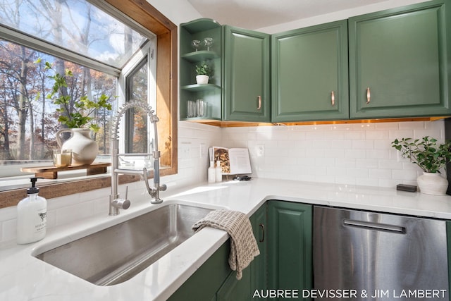 kitchen featuring backsplash, sink, green cabinetry, and dishwasher