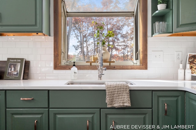 interior details featuring decorative backsplash, green cabinets, and sink