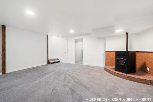 basement with a wood stove and carpet floors