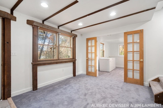 empty room featuring french doors, beamed ceiling, carpet floors, and plenty of natural light