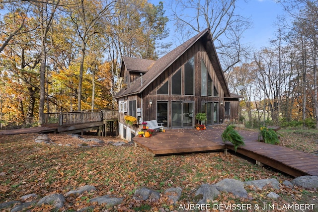 rear view of house with a sunroom and a deck