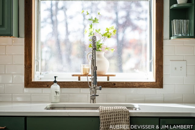 details with sink, green cabinetry, and tasteful backsplash