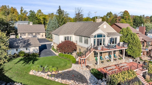 back of house with a deck, a yard, stairway, a chimney, and a patio area