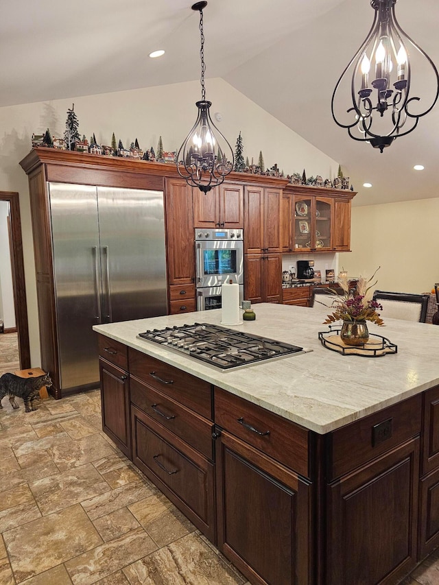 kitchen featuring stainless steel appliances, a notable chandelier, decorative light fixtures, and lofted ceiling