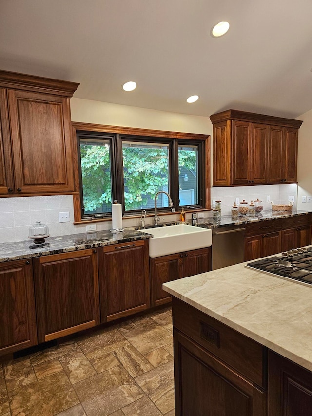 kitchen with backsplash, light stone countertops, sink, and dishwasher