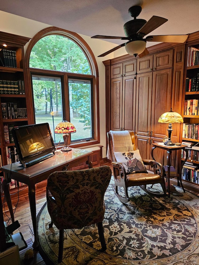 home office with wood-type flooring, a textured ceiling, and ceiling fan