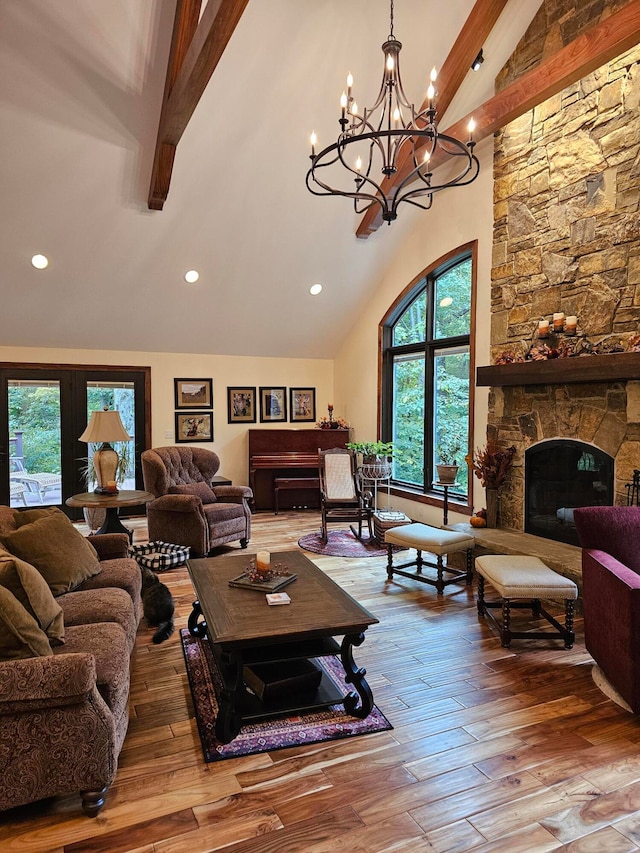 living room with wood-type flooring, beamed ceiling, high vaulted ceiling, and a stone fireplace