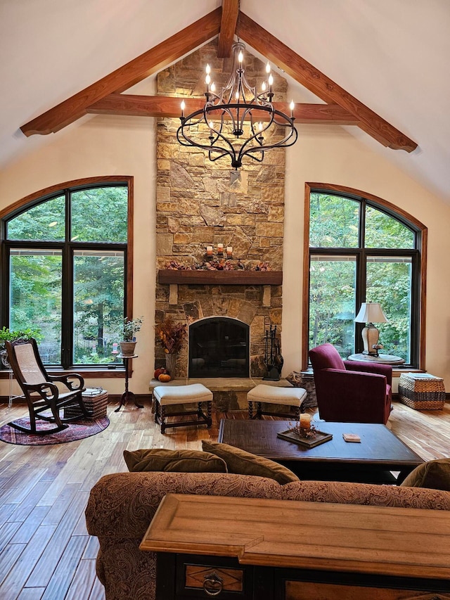 living room with a stone fireplace, hardwood / wood-style flooring, beam ceiling, and a healthy amount of sunlight