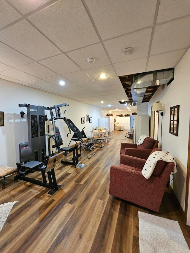 exercise room featuring a paneled ceiling and wood-type flooring