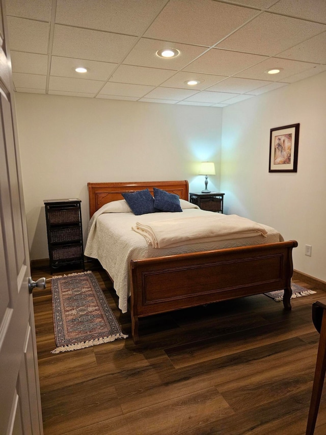 bedroom featuring a paneled ceiling and dark hardwood / wood-style flooring