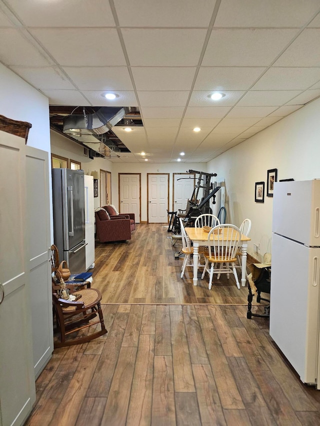 dining area with a drop ceiling and hardwood / wood-style flooring