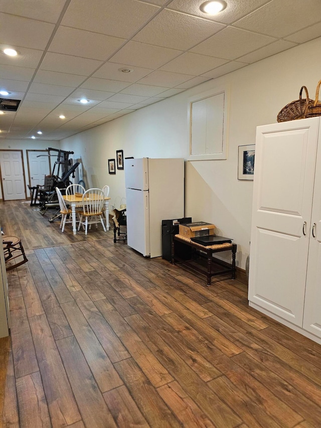 interior space featuring dark wood-type flooring and a drop ceiling