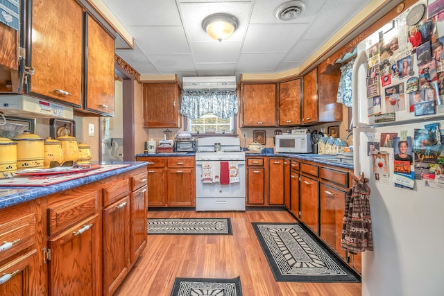 kitchen with white appliances and light hardwood / wood-style floors