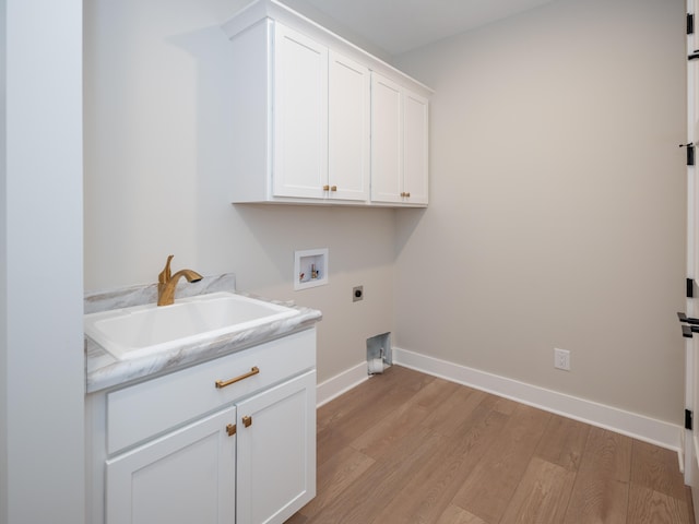 washroom with sink, washer hookup, cabinets, electric dryer hookup, and light hardwood / wood-style flooring