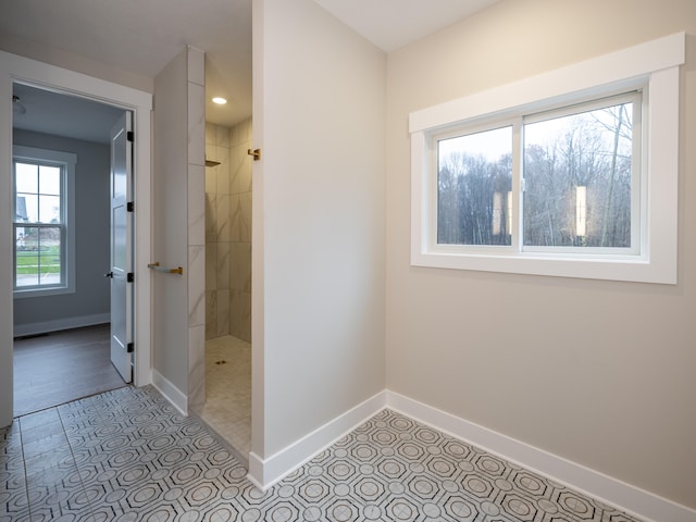 bathroom with tile patterned flooring and a tile shower