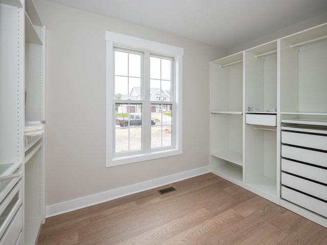 walk in closet with wood-type flooring