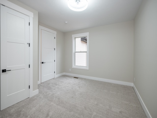 spare room featuring light carpet