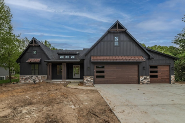 1710 Toscana St, Kalamazoo, MI 49009 - modern farmhouse featuring stone siding, driveway, a standing seam roof, and a garage