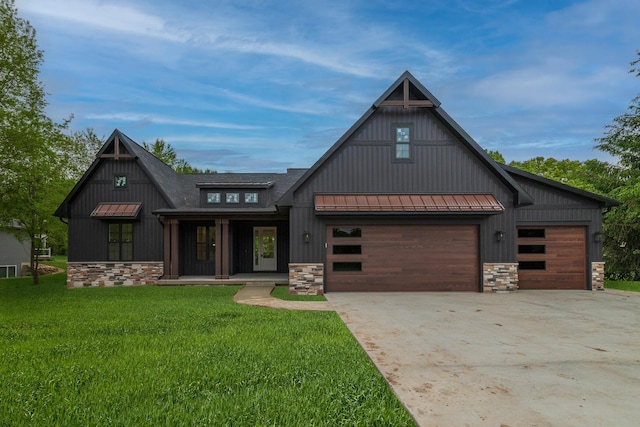 1710 Toscana St, Kalamazoo, MI 49009 - modern farmhouse featuring stone siding, a standing seam roof, concrete driveway, and a front lawn