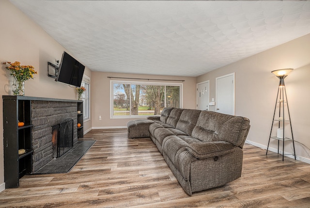 living room with a fireplace, a textured ceiling, and hardwood / wood-style flooring