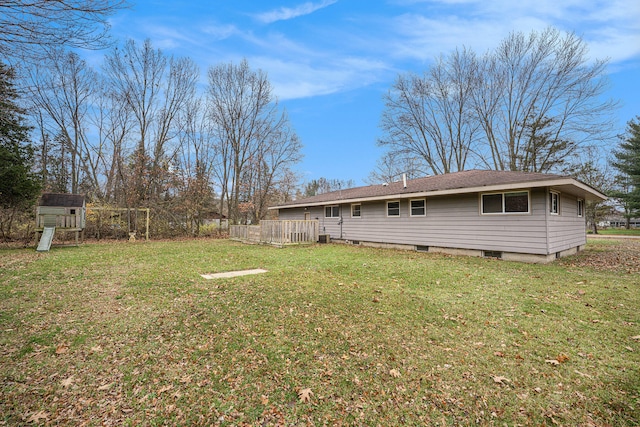 rear view of property with a yard, a playground, and a wooden deck