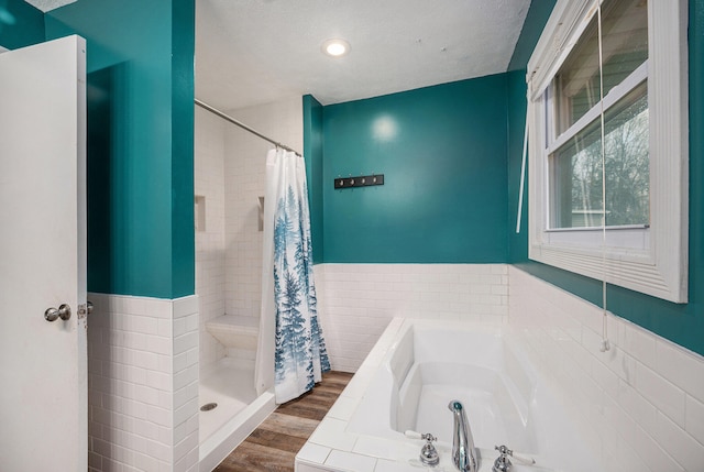 bathroom with hardwood / wood-style floors, a textured ceiling, and plus walk in shower