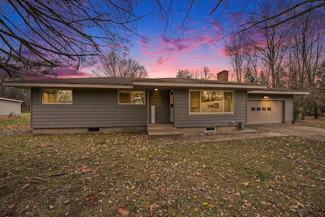 ranch-style home featuring a lawn and a garage