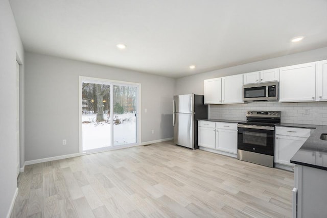 kitchen with white cabinetry, appliances with stainless steel finishes, and backsplash