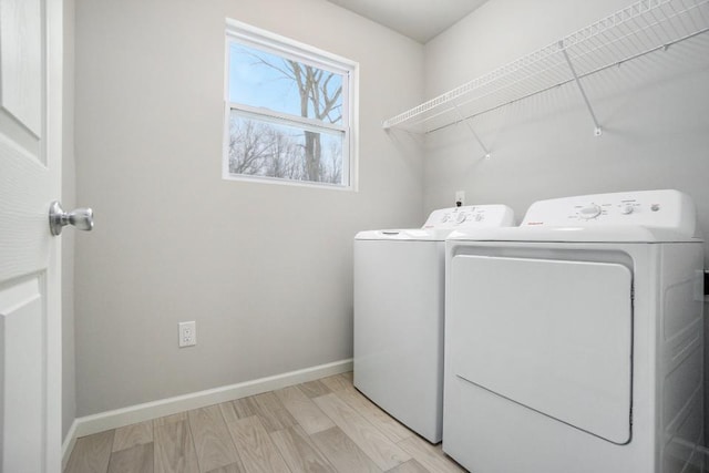 laundry area featuring light hardwood / wood-style flooring and washing machine and clothes dryer