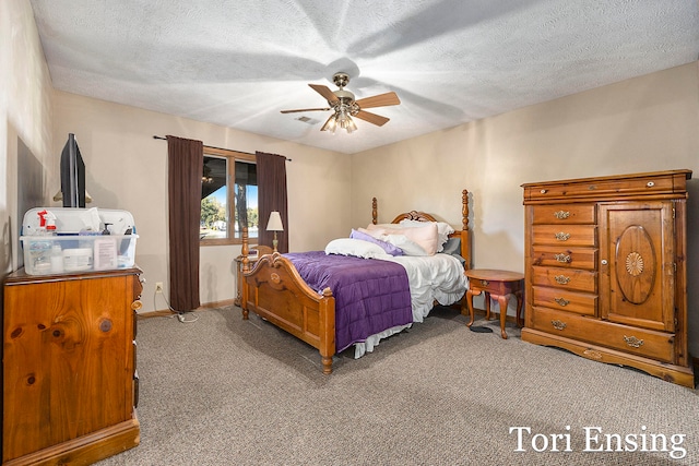 bedroom with ceiling fan, carpet floors, and a textured ceiling