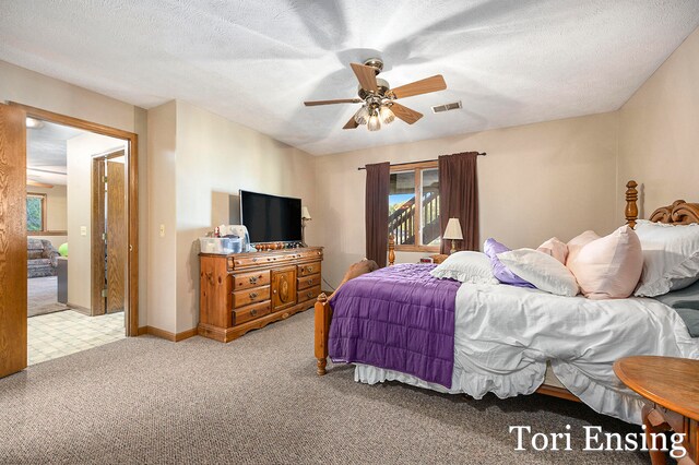 carpeted bedroom featuring ceiling fan and a textured ceiling