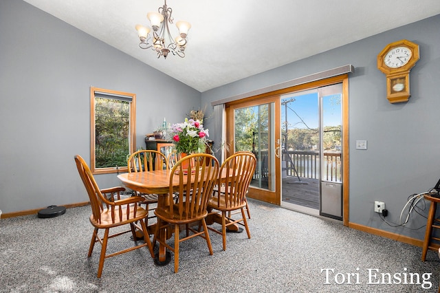 carpeted dining room featuring lofted ceiling, a water view, and a chandelier