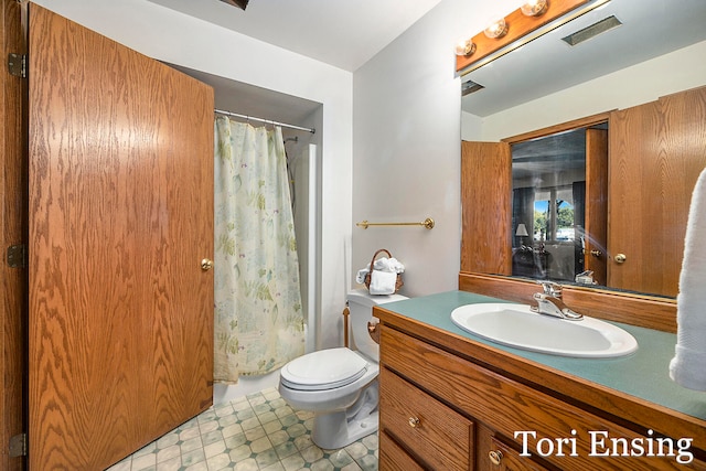 bathroom featuring curtained shower, vanity, and toilet