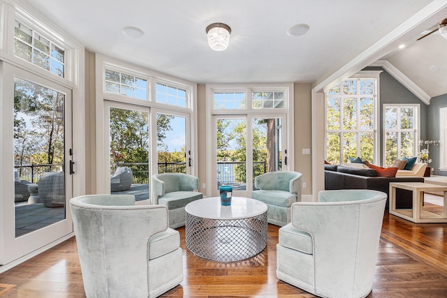 living room with wood-type flooring, vaulted ceiling, a wall of windows, and crown molding