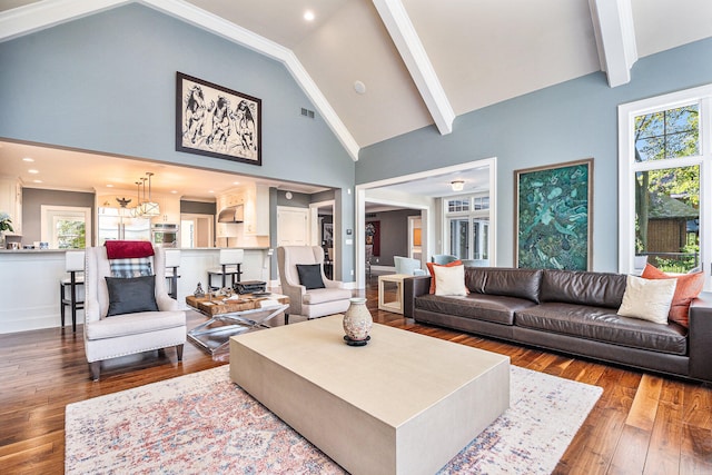 living room featuring plenty of natural light, wood-type flooring, high vaulted ceiling, and a chandelier