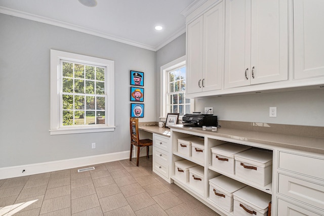 interior space with plenty of natural light, built in desk, and ornamental molding