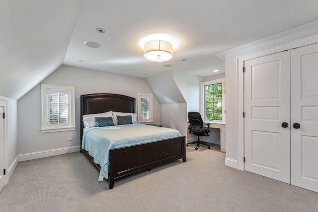 carpeted bedroom with multiple windows, a closet, and lofted ceiling