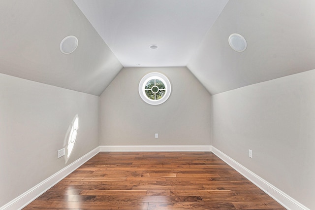 bonus room with vaulted ceiling and dark wood-type flooring