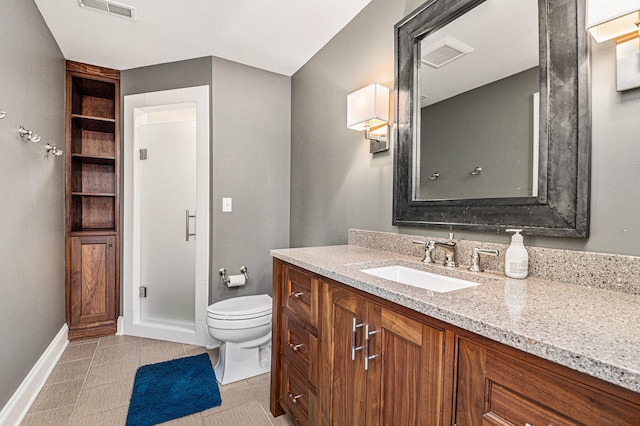 bathroom featuring tile patterned flooring, vanity, toilet, and walk in shower