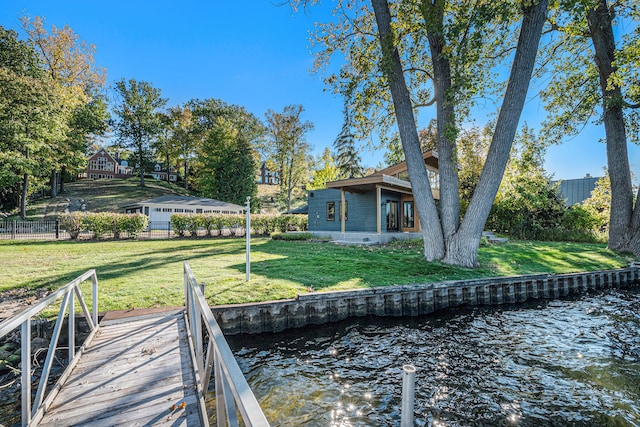 dock area with a lawn and a water view