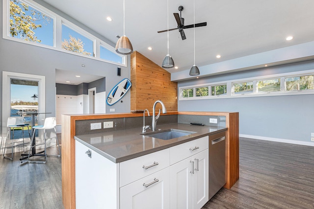 kitchen with dark hardwood / wood-style flooring, stainless steel dishwasher, sink, pendant lighting, and white cabinetry