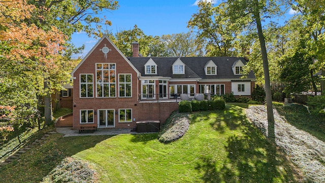 back of property featuring a lawn, a sunroom, central air condition unit, and a patio