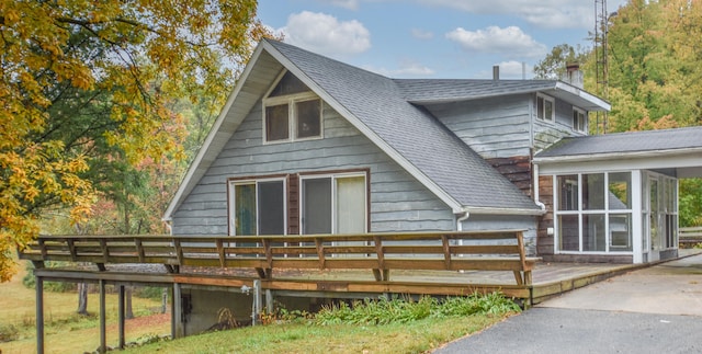 back of property featuring a sunroom and a wooden deck