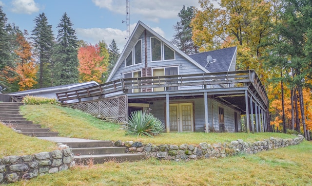 rear view of house featuring a deck and a yard