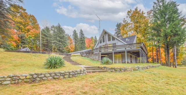 back of house featuring a deck and a lawn