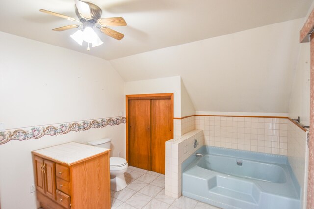 bathroom with tile patterned flooring, ceiling fan, toilet, a bathing tub, and lofted ceiling